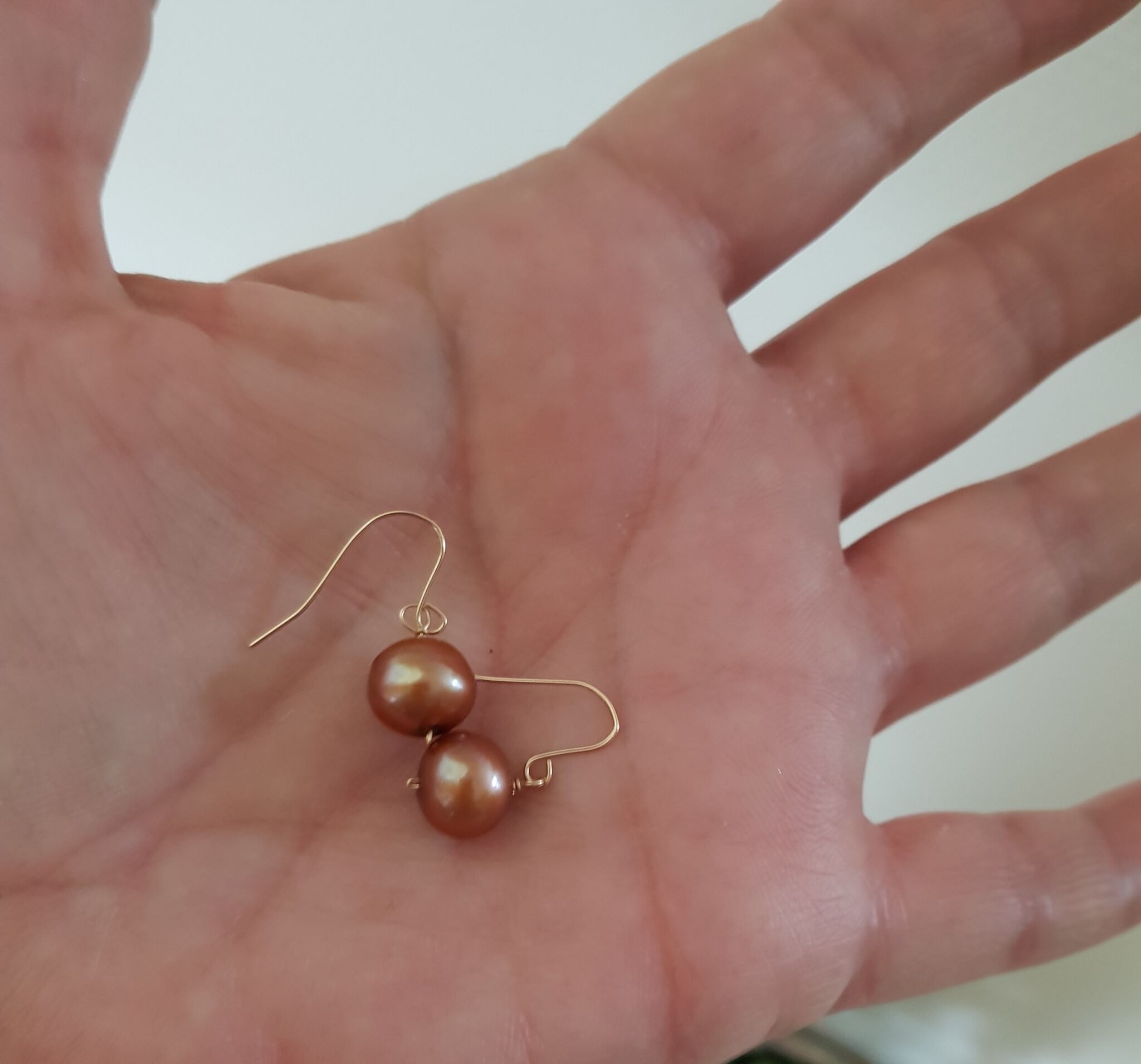 undergrundsbane Gentleman omfattende kobber farvede ferskvands perle øreringe på 11 mm. og 3,5 g. sat på faste  ørebøjler i 10 karat guld.