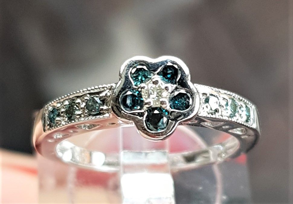blå/hvid diamant ring på 2,6 g. i str. 52,75 i 14 karat m. i alt carat diamanter i SI - I kvalitet og Wesselton- Crystal kvalitet sat i roset samt på ringskinne.